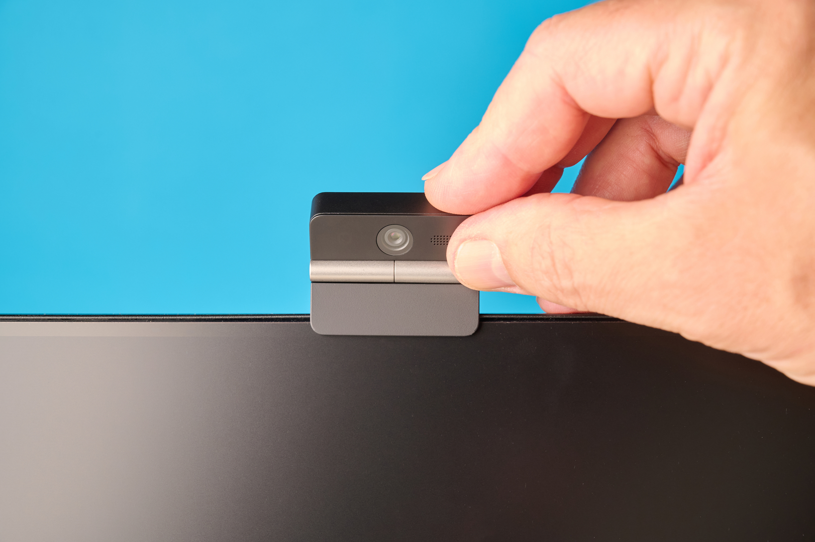 Obsbot Meet Flip foldable webcam photographed in front of a blue background