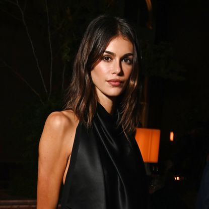 Kaia Gerber wears a black outfit and has shoulder length brunette hair