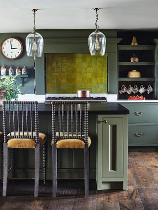 A modern kitchen with a vibrant green tile backsplash and two tall stools at a kitchen island