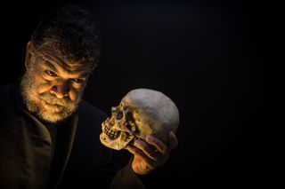 Man holding skull, contemplating death.