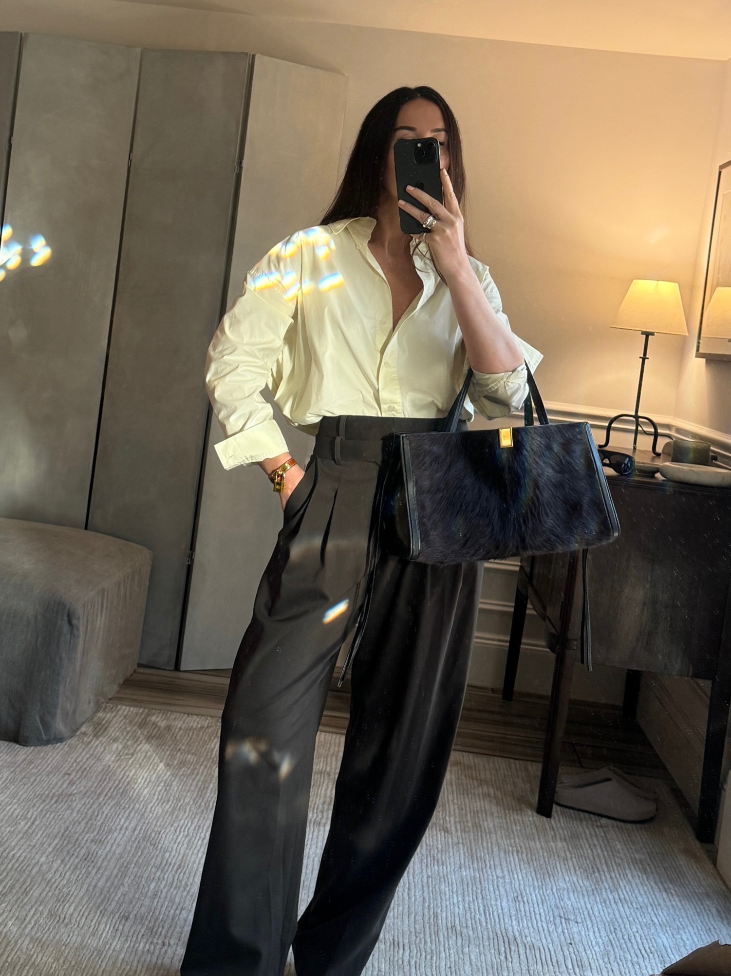 Caitlin Burke wearing a white button-down shirt with black trousers and carrying a black Phoebe Philo Kit Cabas bag with pony hair.