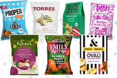 Cut-outs of Proper, Torres, Rude Health and other brands of the healthiest crisps on a blue speckled background