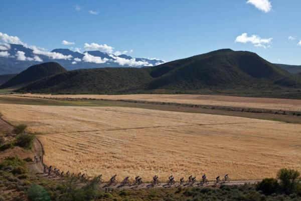 A group of riders wind its way along a gravel road early on during stage 4