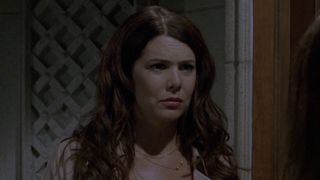 Lorelai looking confused in a jacket at the door of Richard and Emily's house.