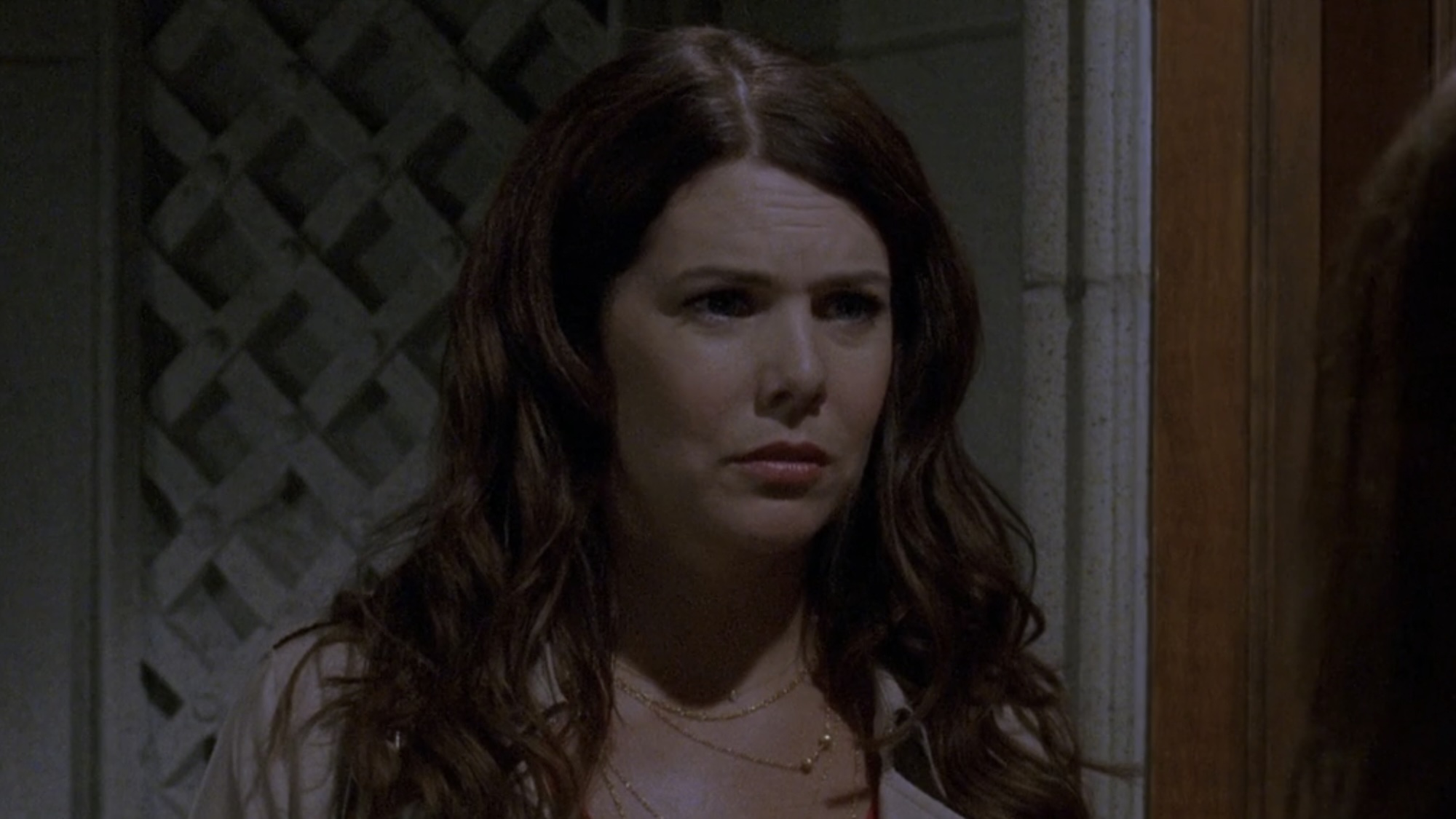 Lorelai looking confused in a jacket at the door of Richard and Emily's house.