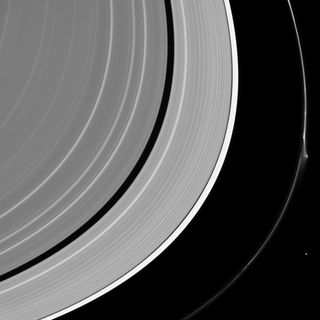 Saturn's rings reach across the photo, and the outermost, thin one 