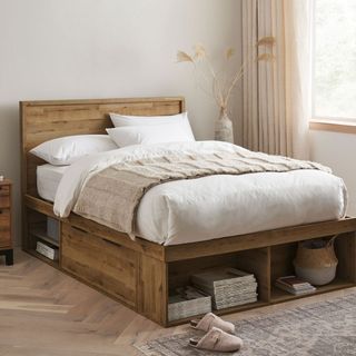 Wooden bed frame in white bedroom