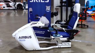 A side-on photograph of the Trak Racer TR550 flight simulator cockpit in white and blue showcasing the Airbus logo and Airbus licensed flight controllers. 