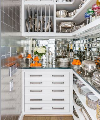 Chef's kitchen with silver tiles and white cabinets