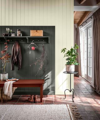 hallway with small stone flags on floor, panelled walls and boot area marked out with dark green paint