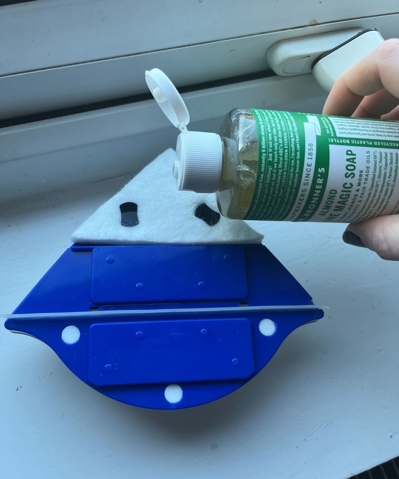 Pouring castile soap onto the cleaning pad