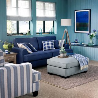 living room with blue sofa white and blue cushion and lamp