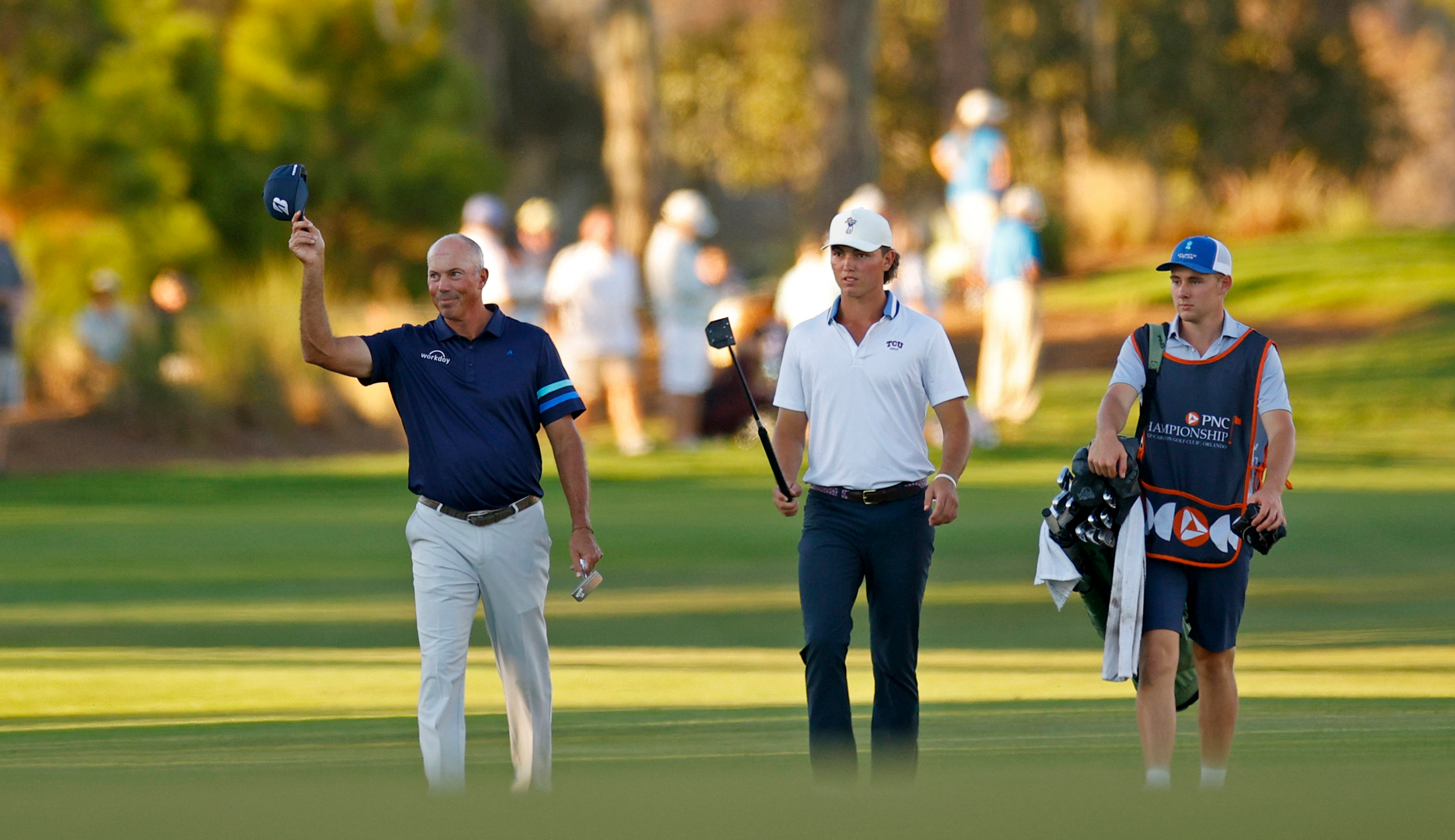 Matt Kuchar and his son walk down the fairway