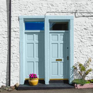 Two baby blue front doors on white cottages