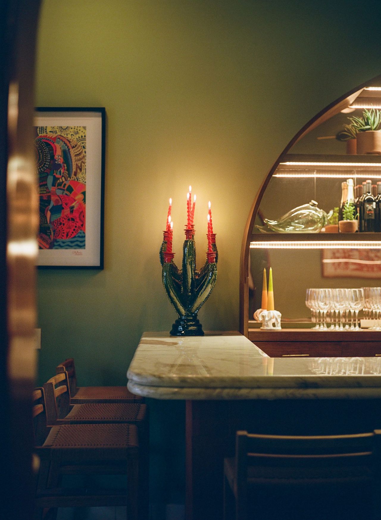 A vibrantly decorated hotel boasts a welcoming palette of pastel greens, pinks, and browns, softly glowing lighting, and a retro-fueled energy.