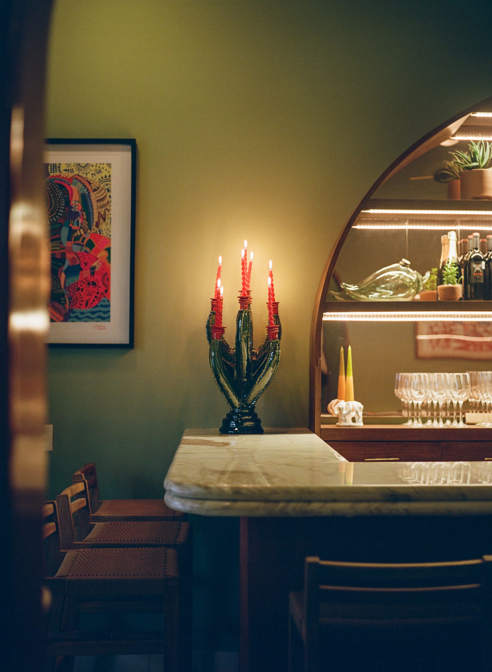 A vibrantly decorated hotel boasts a welcoming palette of pastel greens, pinks, and browns, softly glowing lighting, and a retro-fueled energy.