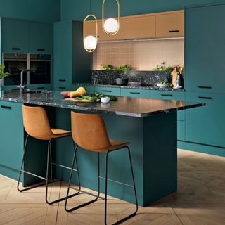 Bold teal kitchen with black worktops and wood floors