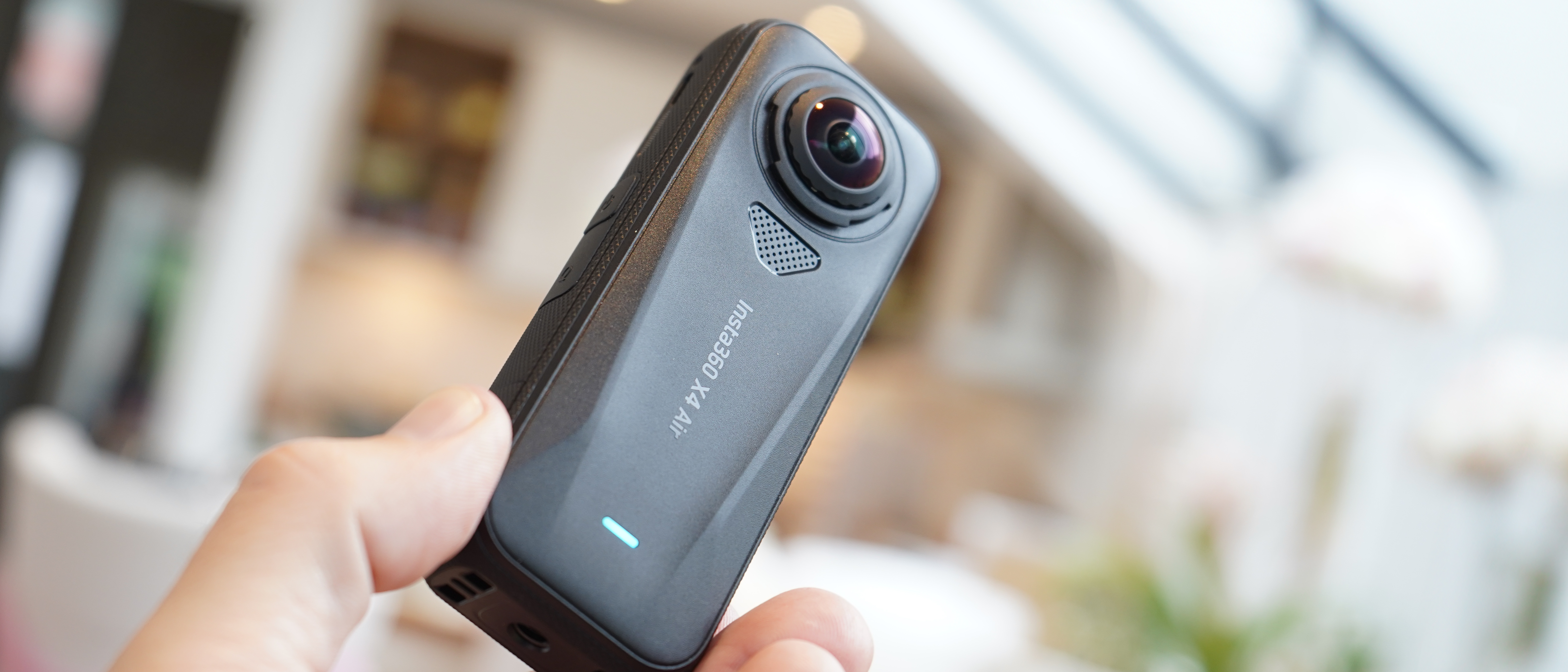 Insta360 X4 Air held in someone&#039;s hand outdoors