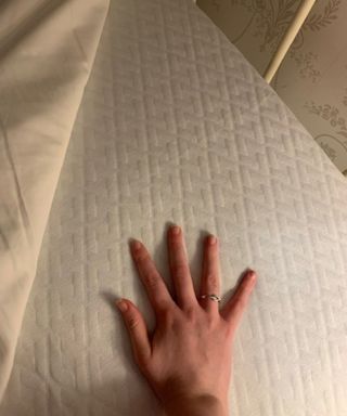 A hand pushing down on the Linenspa Mattress Topper.