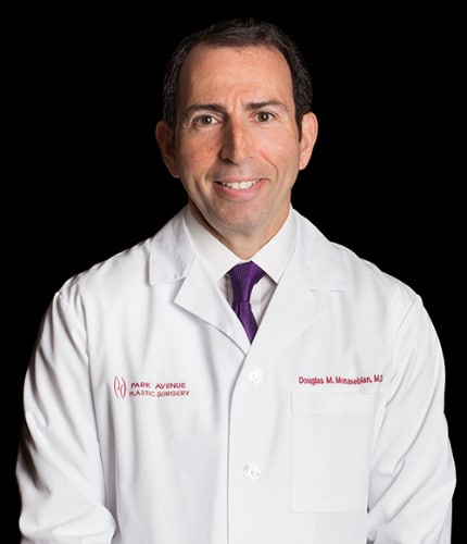 a photo of a white man wearing a white lab coat in front of a black background