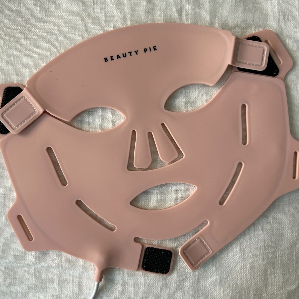 The new Beauty Pie LED mask on a white linen background
