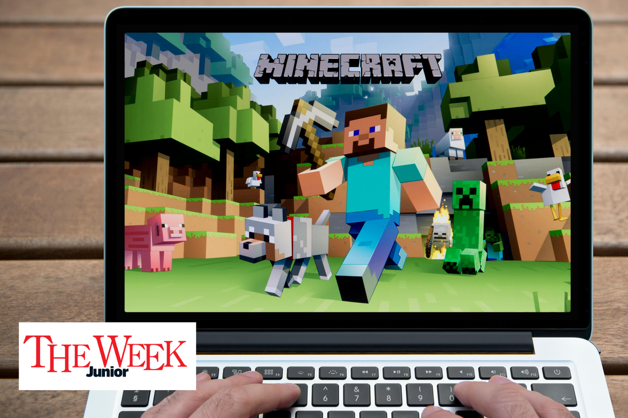 A picture of the game minecraft on a laptop with some hands playing on the keyboard next to the logo for The Week Junior 