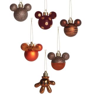 room with white wall having hanging bronze disney baubles