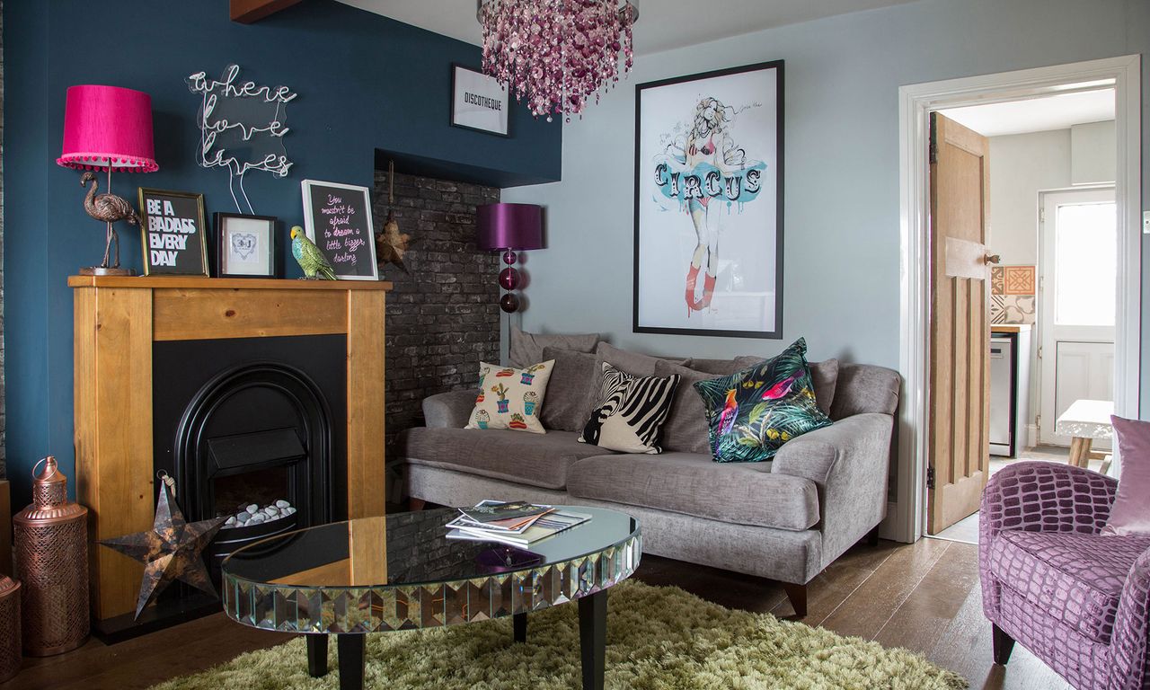 living area with grey sofa and wooden floor and fire place