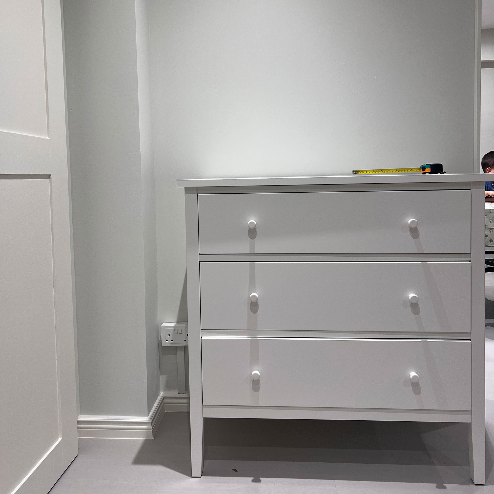 White chest of drawers in neutral room