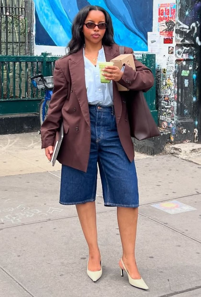 @aysha.sow wears a brown relaxed blazer, light blue button-up shirt, jean shorts and white slingback low heels
