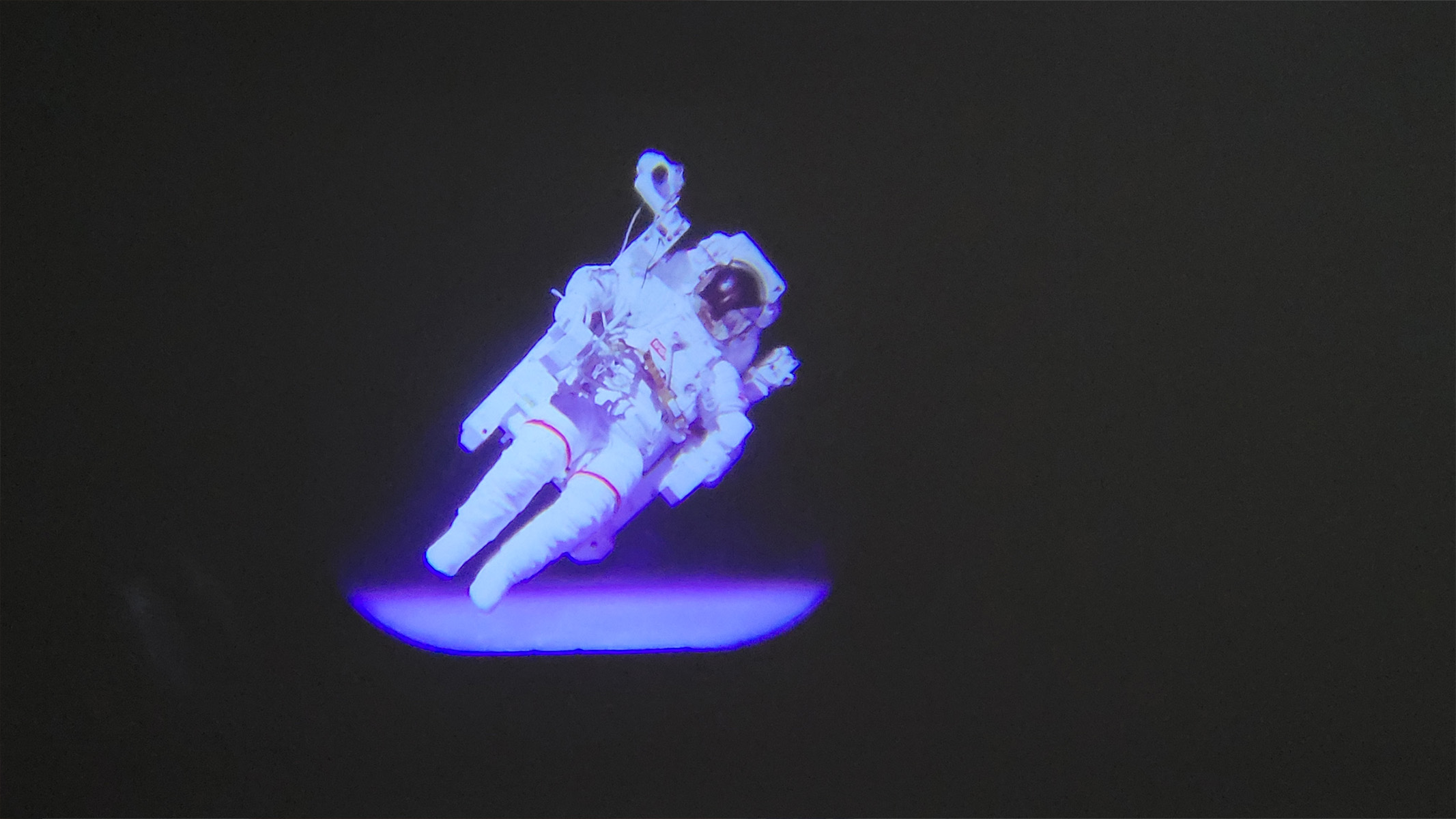 L'image montre une projection d'un astronaute faisant un tour de l'espace