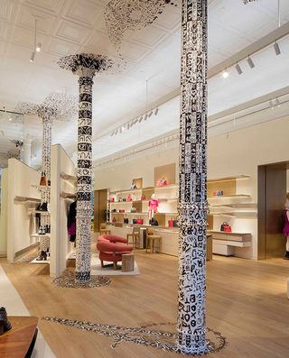 The space features columns decorated in black and white symbols, handpainted by the Japanese artist Mukai Shuji