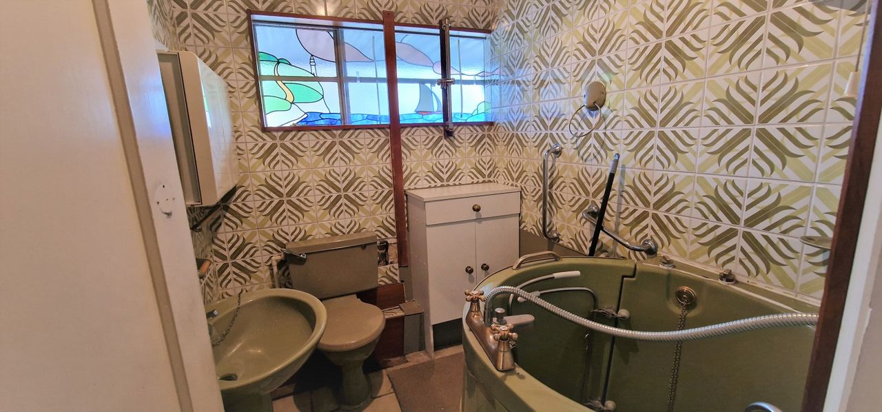 The bathroom is a deep olive green colour