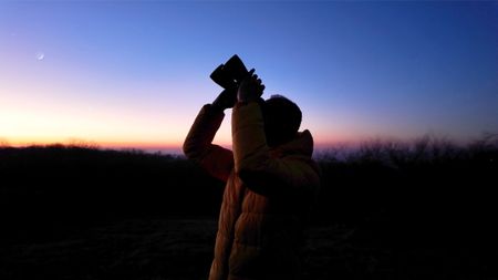 man using binoculars for astronomy