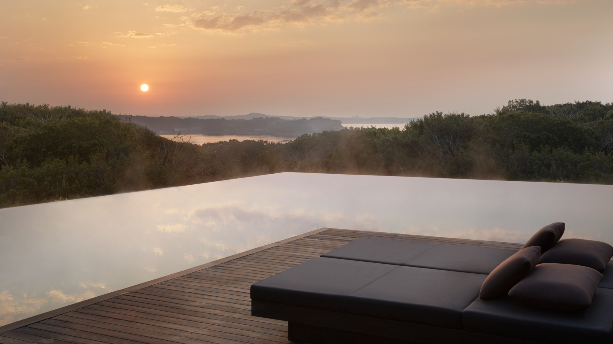 A poolside terrace at Amanemu at sunset