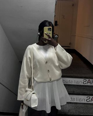 Influencer wears a white mini skirt.