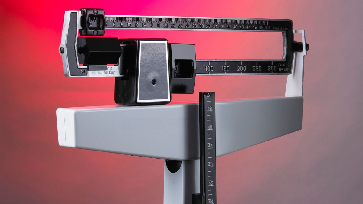 a doctor&#039;s office scale shown against a white and red gradient background