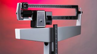 a doctor's office scale shown against a white and red gradient background