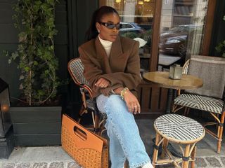 @nlmarilyn wears rich mom style blazer and denim sitting outside at Paris cafe