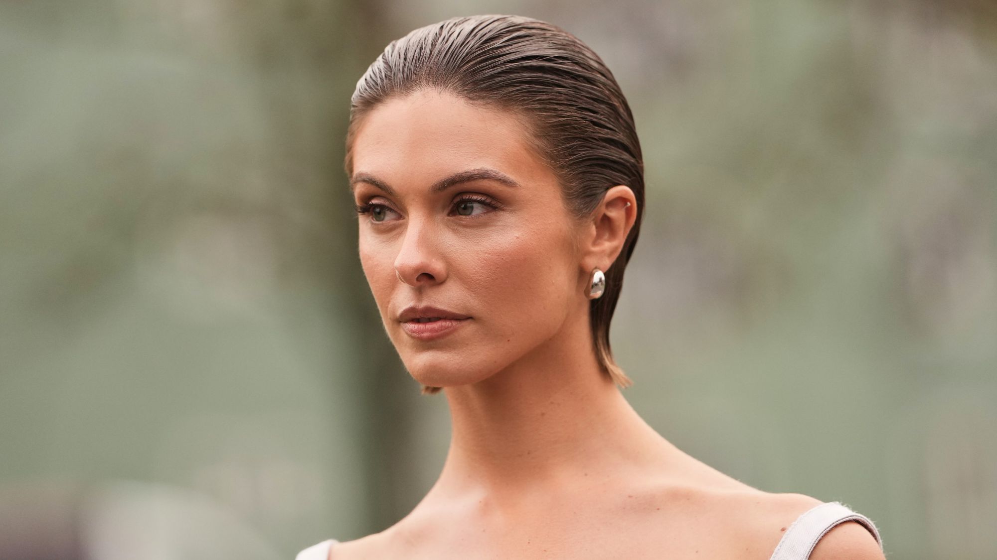 woman with slicked back hair and bronzed skin