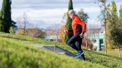 Older man runs up steps outdoors in activewear