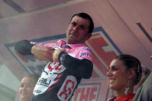 Ivan Basso puts on another maglia rosa on the podium in Brescia