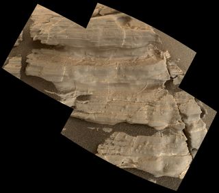 An image from Gale Crater taken by the Curiosity rover on Mars. The inset shows a v-shaped feature that may have formed over a mineral crystal.