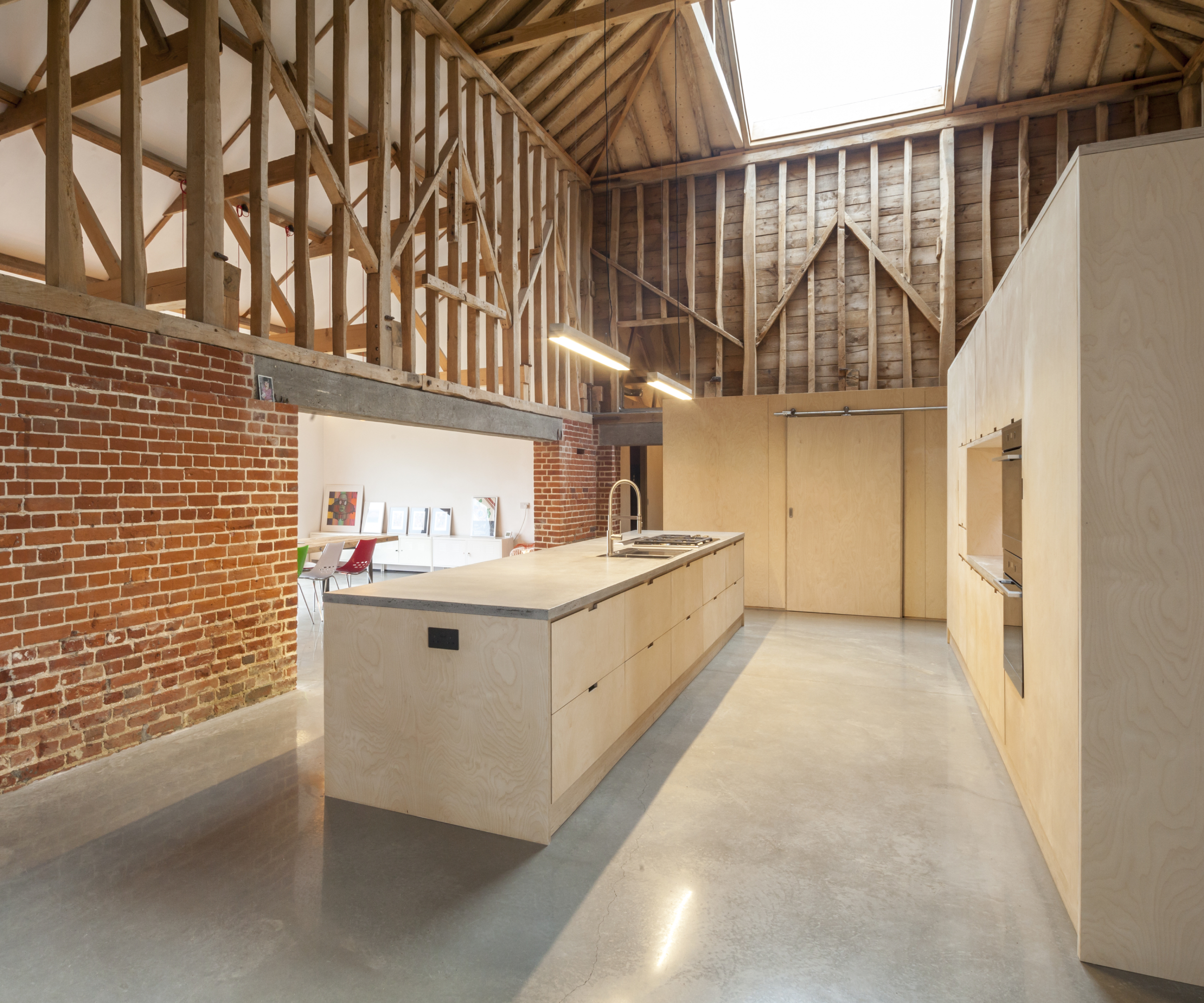 inside barn conversion with large rooflight above kitchen and open timber walls