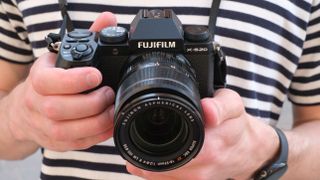 Best mirrorless camera Fujifilm X-S20 held in mans hands