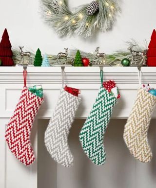 Stockings hanging from a mantel beneath a wreath.