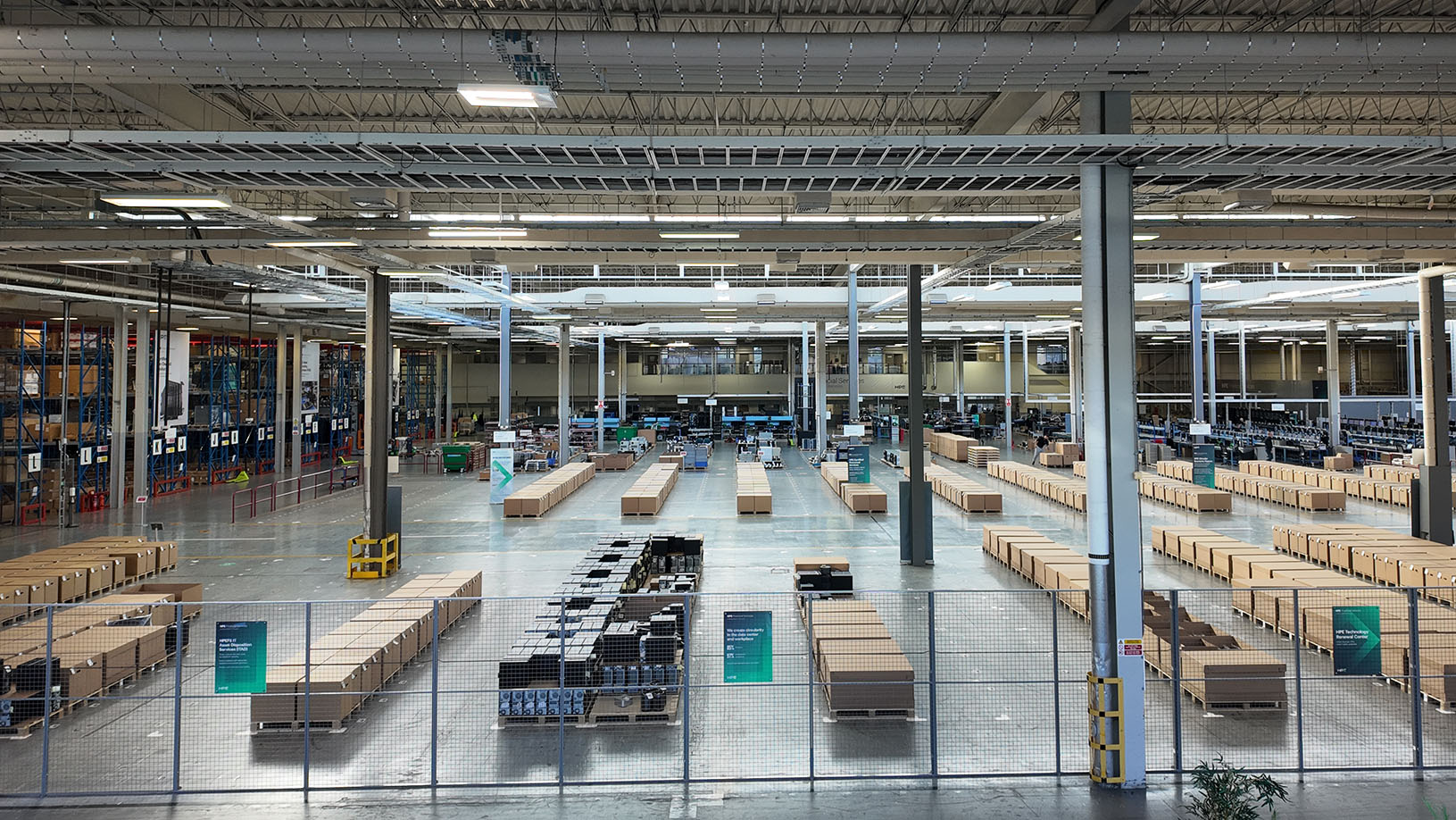 A wide shot of a distribution facility where several rows of boxes are lined up on the floor.