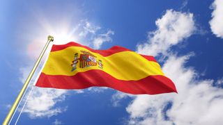 Popular Spanish Idioms: Image shows yellow and red Spanish flag against blue sky background