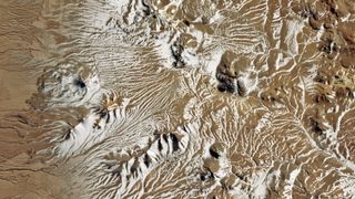 A zoomed out map of the Atacama desert in Chile shows snow dotting hills and valleys. 