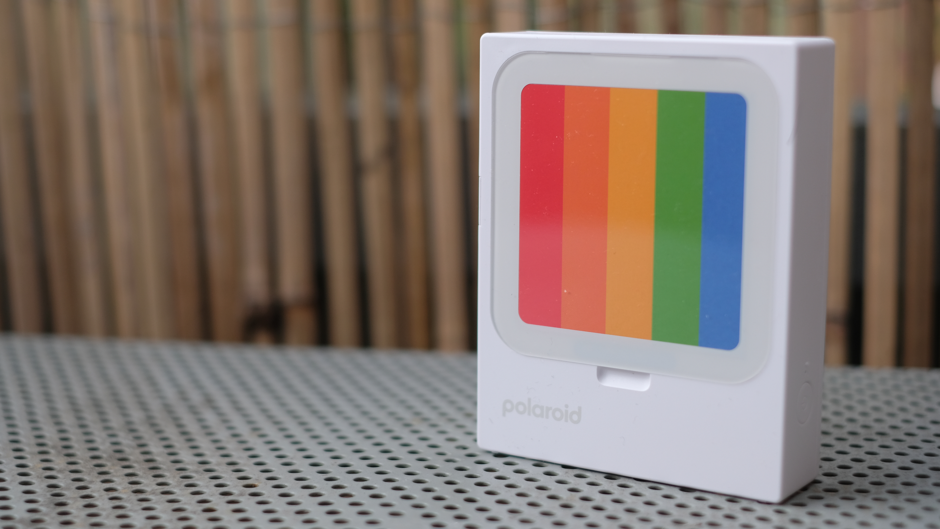 Photograph of Polaroid Hi-Print 3x3 mini instant printer standing with placeholder rainbow card in display slot.